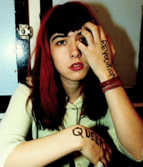 a woman with red hair and tattoos on her arm