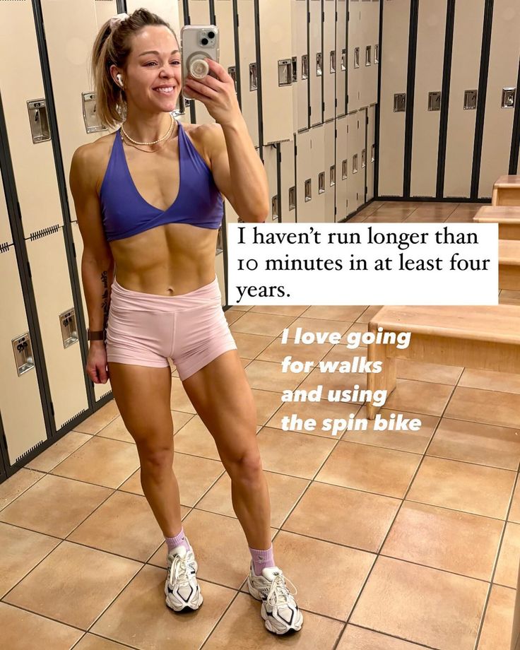 a woman taking a selfie with her cell phone in a locker room full of lockers