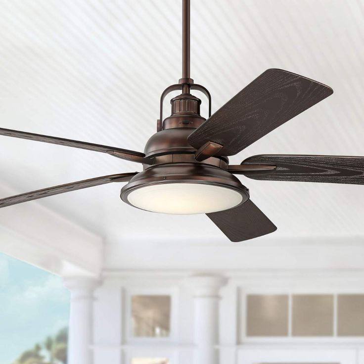 a ceiling fan that is hanging from the ceiling in a room with white walls and windows