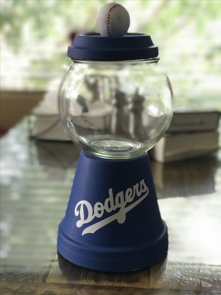 a dodgers baseball in a glass ball dispenser on top of a table