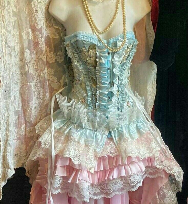 a mannequin wearing a dress made out of laces and fabric with pearls