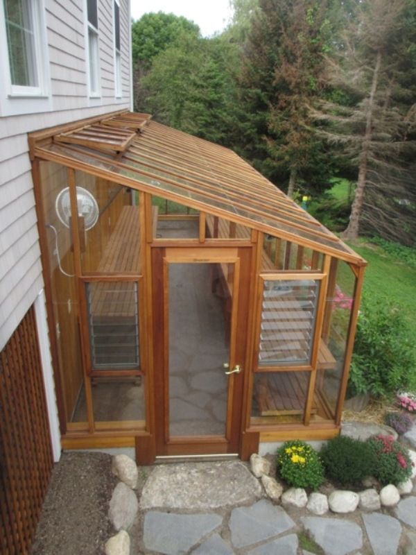 a small wooden building with a glass door on the front and side walk up to it