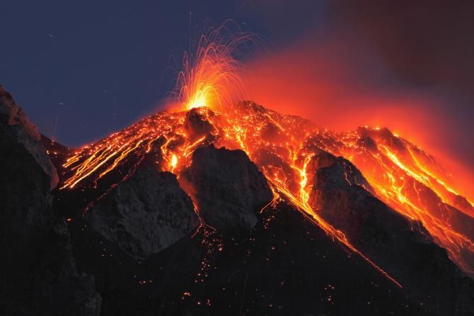 the top of a mountain is lit up with lava