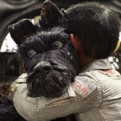 a man is holding a dog in front of him and he has his head on the back of another person's shoulder