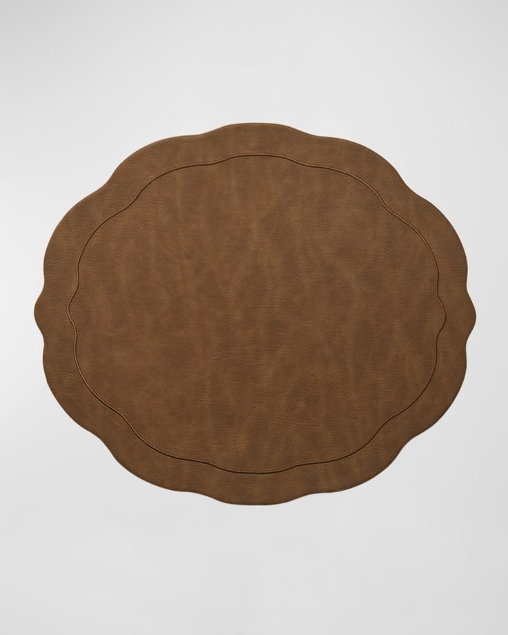 a round brown leather placemat on a white background