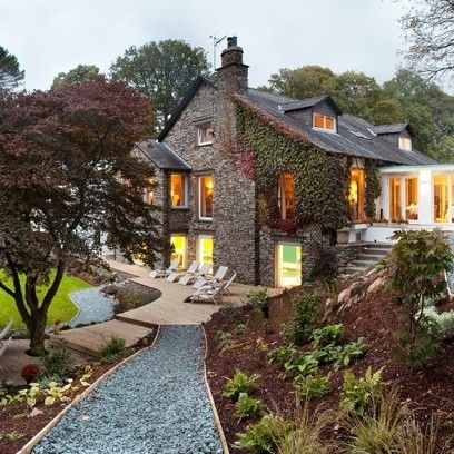 a large house with lots of windows next to a small garden and walkway leading up to the front door