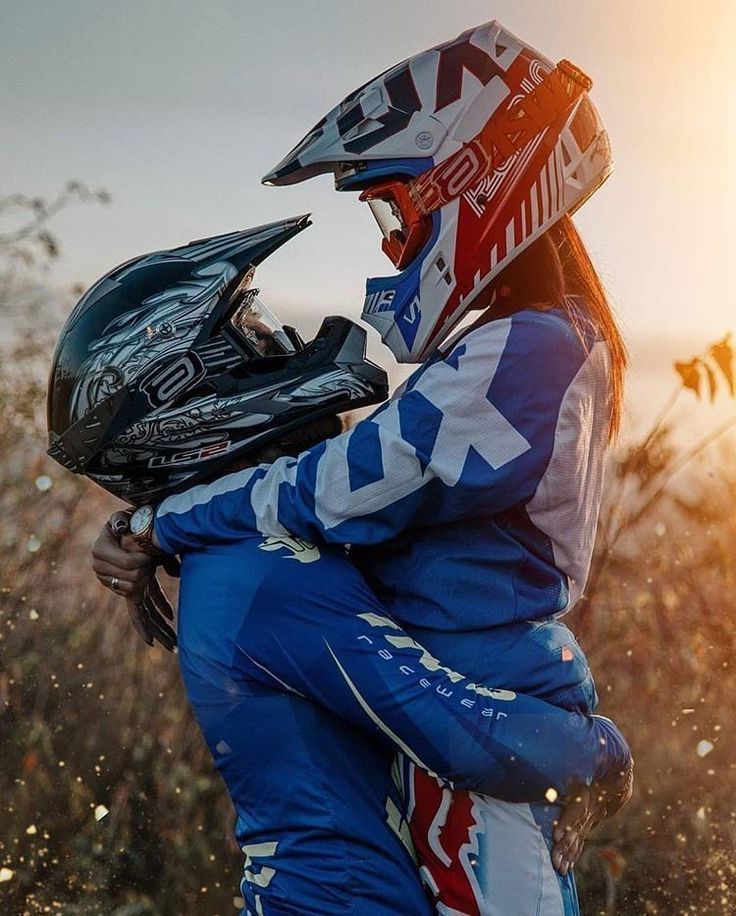 a person with a helmet on hugging another person