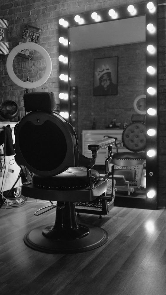 a black and white photo of a chair in front of a mirror with lights on it