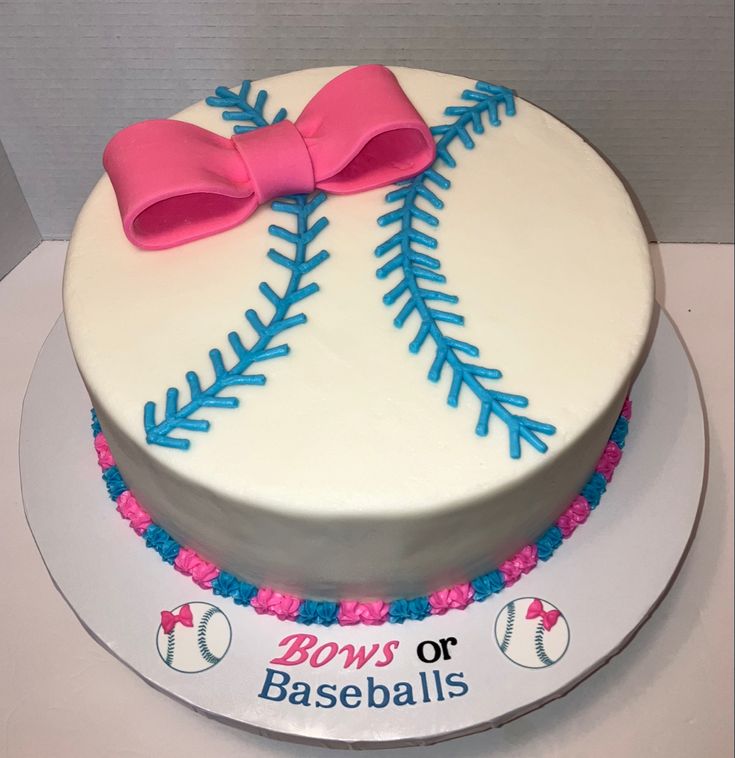 a cake decorated with a baseball and pink bow