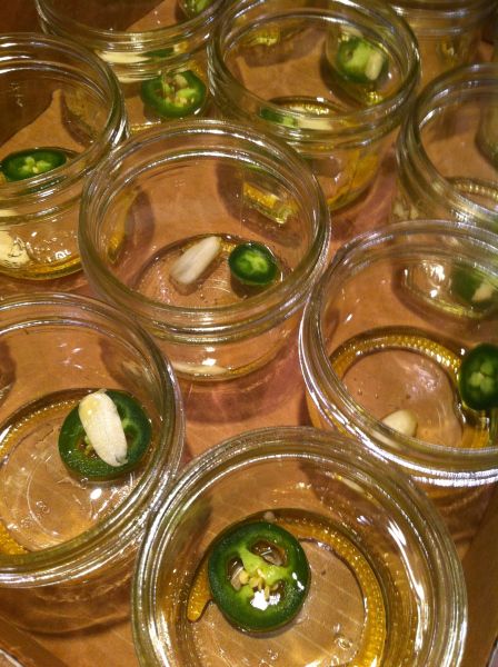 several glass jars filled with pickles and other vegetables on top of a wooden table