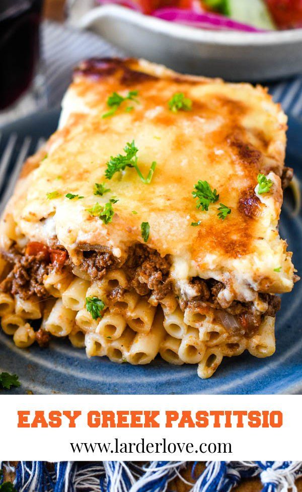 easy greek pasta casserole with meat and cheese on a blue plate next to a bowl of salad