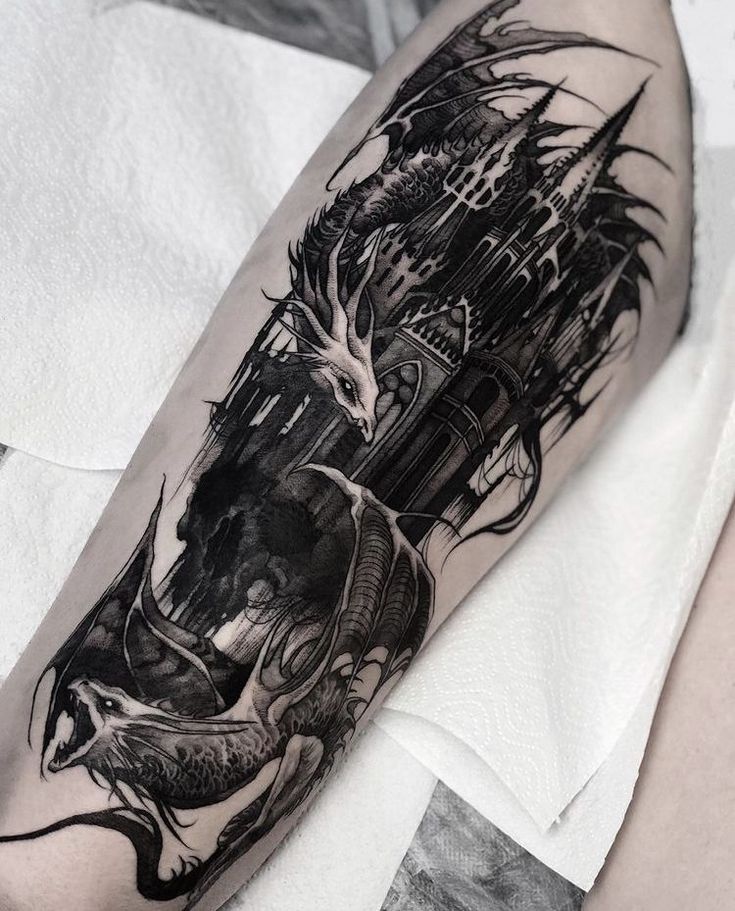 a man's arm with a black and white tattoo design on the left forearm