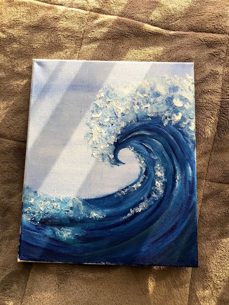 an acrylic painting of a wave in the ocean on a sheet of paper