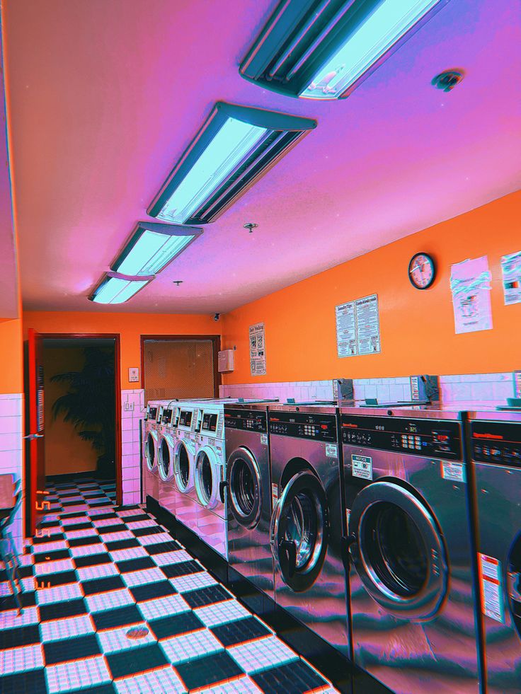 an orange and black checkered floor in a laundry room with washers and dryers