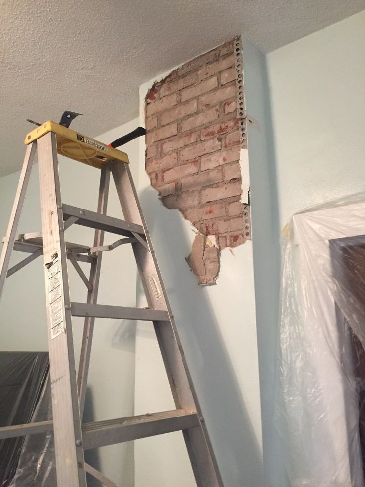 a ladder that is next to a brick wall in the process of being painted and installed