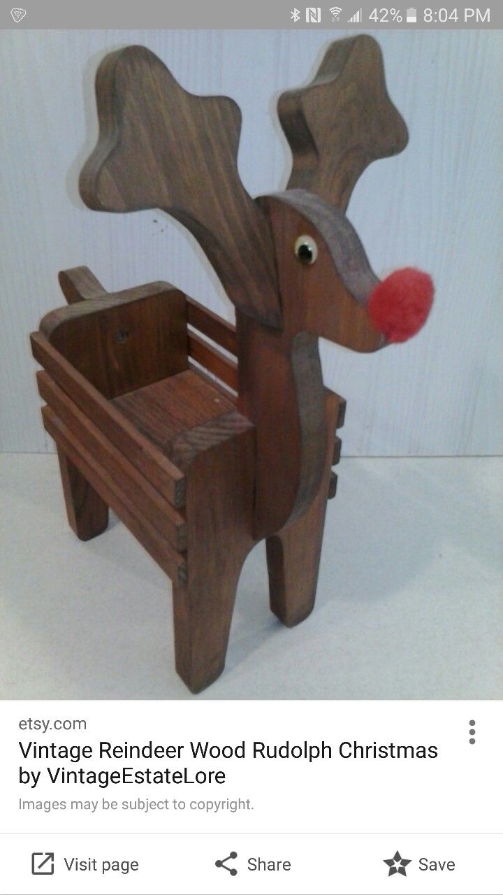 a wooden reindeer chair with a red nose