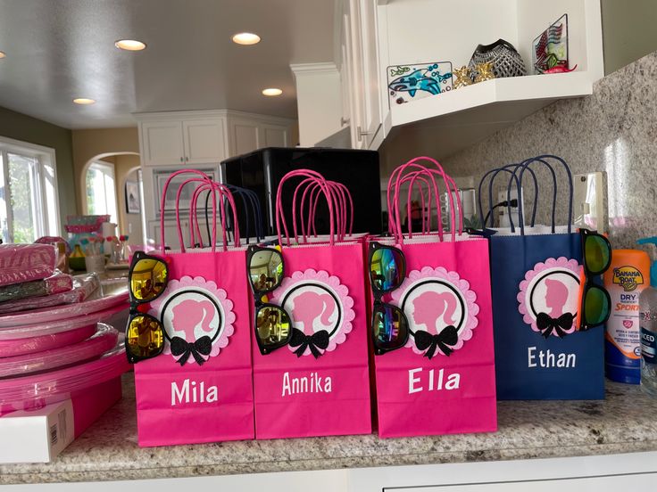 pink and blue shopping bags with personalized name on them sitting on a kitchen counter