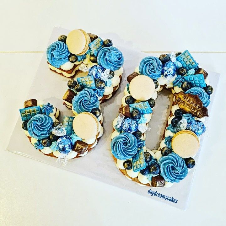 the number 50 decorated with blue and white icing on top of a sheet of paper