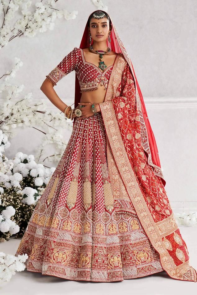 Red raw silk lehenga with attached can-can, all over vintage jaal pattern, resham, sequin and zardozi embroidery. Paired with sweetheart neck padded blouse with all over jaal pattern embroidery, bead tasselled hem, bandhani embroidered dupatta and organza dupatta.
Components: 4
Pattern: Embroidered
Type Of Work: Resham, Sequin and Zardozi Work
Neckline: Sweetheart Neck
Sleeve Type: Half Sleeves
Fabric: Raw Silk, Dupatta: Bandhani, Dupatta: Organza
Color: Red
Other Details: 
Cut work blouse hem
E Red Traditional Lehenga For Ceremony, Traditional Red Lehenga For Ceremony, Red Embroidered Lehenga For Ceremony, Red Festive Traditional Wear For Ceremonies, Red Traditional Wear With Zari Work For Ceremony, Red Sets With Pallu For Ceremony, Red Embroidered Ceremony Sets, Fitted Red Traditional Wear For Ceremonies, Ceremonial Red Sets With Intricate Embroidery