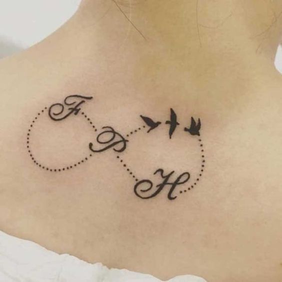 the back of a woman's neck with two birds flying in opposite directions to each other