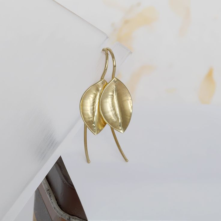 These unique hammered gold leaf earrings are handmade of yellow 14k solid gold. The leaves have a delicate texture formed as I was hammering the gold to give them their leaf shape. Each leaf is unique, and you can instantly see they are made by hand. Their finish is matte with shiny edges. These lovely gold earrings have an organic feel, are light and easy to wear, and will look beautiful with any outfit. Silicone ear backs are included for safety. Leaf's size is approx. 10 x 15.5 mm = 0.4 x 0.6 inch Earrings total length is: approx. 32 mm = approx. 1.25 inch * The earrings will be packed in a gift box ready to give as a gift, and shipped via Express mail service which usually takes 4-6 business days to arrive. * To see more gold earrings click here:  http://www.etsy.com/shop/SigalGerson?s Yellow Gold Leaf-shaped Earrings For Pierced Ears, Yellow Gold Leaf-shaped Brass Earrings, Yellow Gold Leaf Earrings, Minimalist Gold Leaf Earrings, Leaf Earrings Gold, Unique Handmade Earrings, Earrings Nature, Real Gold Jewelry, Gold Leaf Earrings