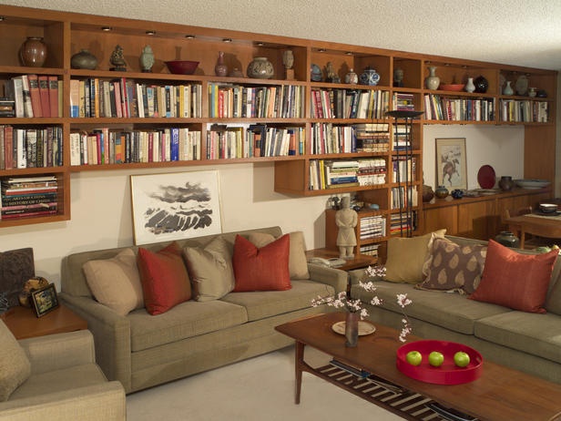 a living room filled with lots of furniture and bookshelves