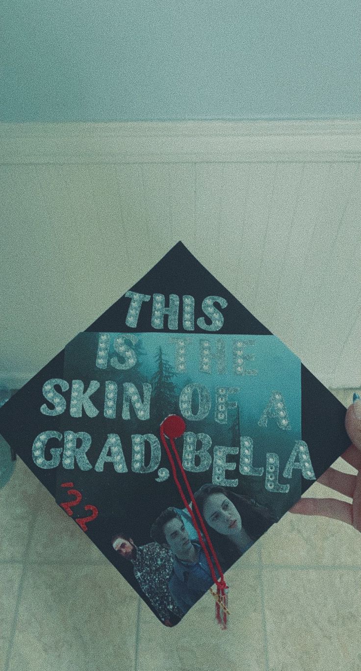 someone holding up a graduation cap that says, this is the skin of a grad - bela