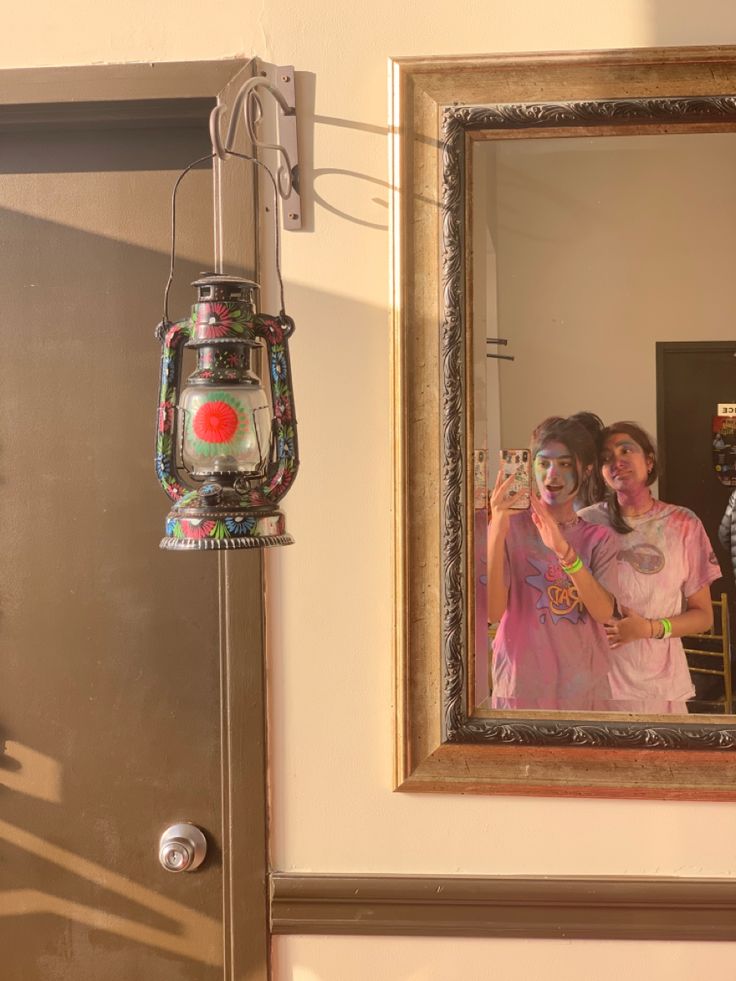 two people are taking a selfie in front of a mirror with a camera attached to it