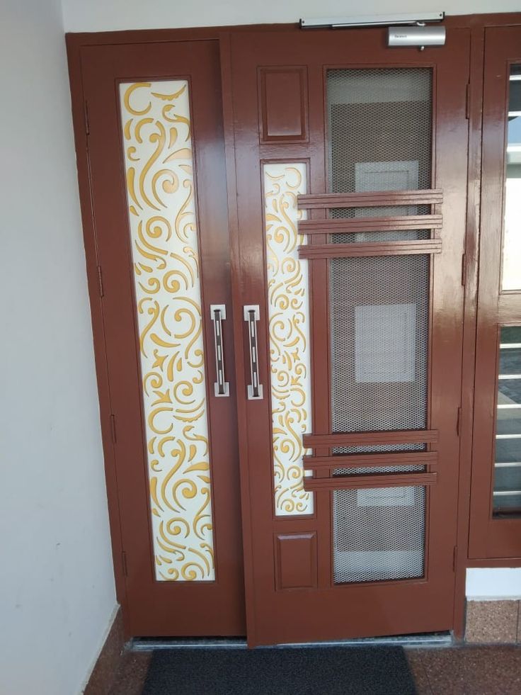 two brown doors with decorative glass panels on them