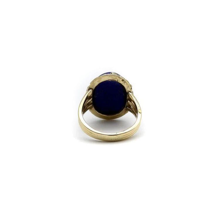 This is part of Chairish’s Fine Jewelry assortment.  A vivid blue lapis cabochon is bezel set into a halo of 22k gold nuggets. The stone is a deep, well-saturated cobalt blue, while the gold nuggets bring richness and texture to the surface of the ring. The effect is stunning, and the two elements compliment each other beautifully. The 14k gold band splits into three, adding a hint of drama and elegantly framing the lapis centrepiece. A bold cocktail ring, true blue!  This type of nugget work ar Blue Cabochon Sapphire Ring In 14k Gold, Gold Lapis Lazuli Jewelry With Cabochon, Gold Lapis Lazuli Cabochon Jewelry, Yellow Gold Lapis Lazuli Cabochon Jewelry, Formal Lapis Lazuli Gemstone Ring, Blue 14k Gold Oval Cabochon Jewelry, Blue Cabochon 14k Gold Ring, Yellow Gold Sapphire Cabochon Ring, Gold Oval Lapis Lazuli Jewelry