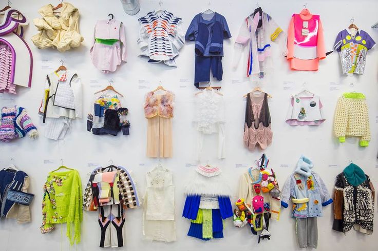 there are many different types of clothes hanging up on the wall, including ones in pink, blue and yellow