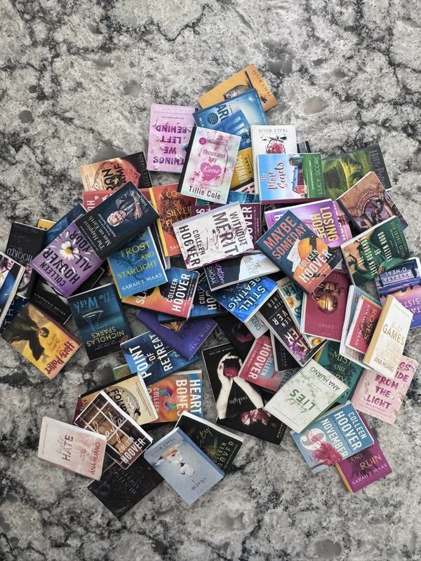 a pile of books sitting on top of a marble counter next to a knife and fork