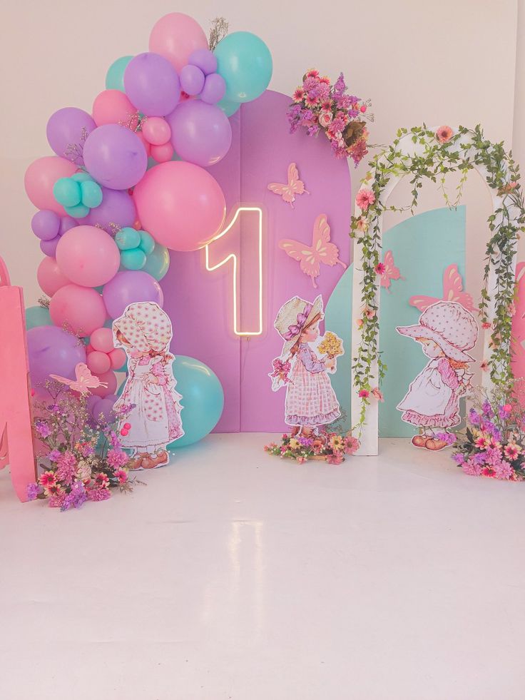 there are balloons and decorations on the floor in front of a pink wall with flowers