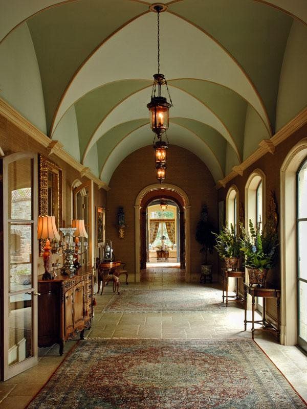 a large hallway with arched windows and an area rug on the floor that is covered in carpet