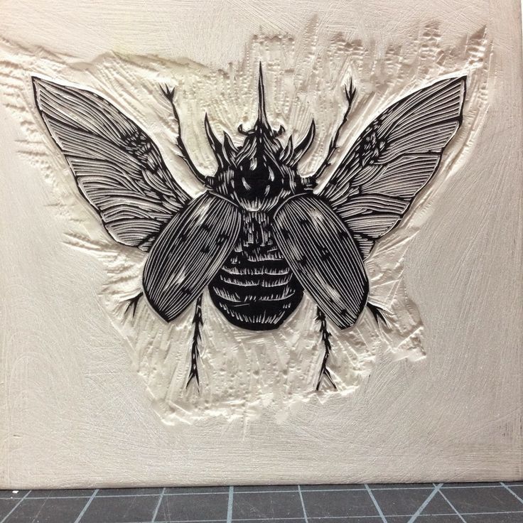 a black and white drawing of a bee on a beige wall with tile flooring