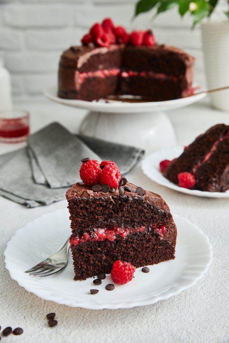 a piece of chocolate cake with raspberries on top and one slice missing from it