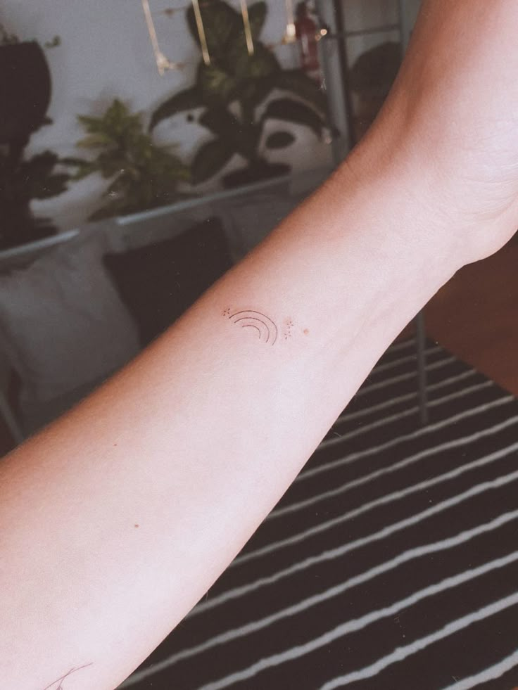 a person's arm with a small tattoo on the left side of their arm