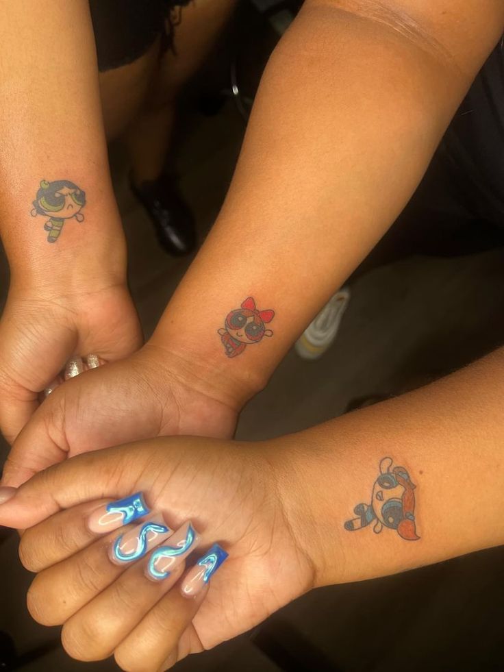 two girls with matching tattoos on their arms are holding each other's hands together