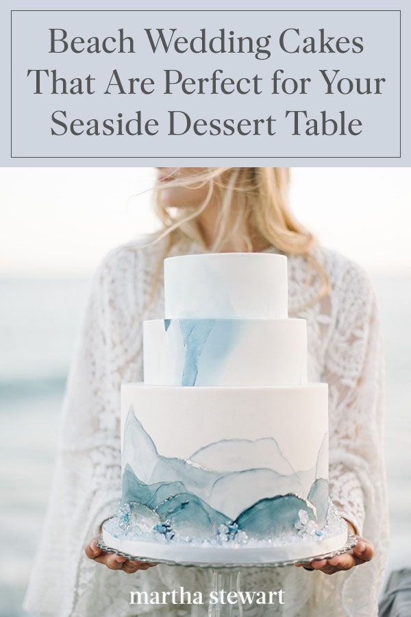 a woman holding a white and blue wedding cake