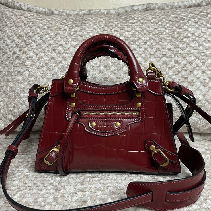 Brand New, Comes With Dust Bag But No Box Please Be Aware Of That Family & Friends Sales Doesn’t Have Standard Packaging. Color : Burgundy Dimensions : L8,6 X H5,5 X W4,3 Inch Embossed Calfskin Two Leather Hand-Braided Handles Adjustable And Removable Leather Strap Zipped Closure With Knotted Leather Puller Tone-On-Tone Logo Embossed On Front Front Zipped Pocket With Knotted Leather Puller 1 Inner Flat Pocket Nappa Lambskin Bonded Lining Made In Italy Wipe With A Soft Cloth Free Authentication F Designer Burgundy Rectangular Bag, High-end Red Shoulder Bag With Branded Hardware, Designer Burgundy Shoulder Bag For Shopping, Luxury Burgundy Shoulder Bag With Branded Hardware, Luxury Burgundy Crossbody Satchel, Designer Burgundy Shoulder Bag With Branded Hardware, Designer Burgundy Top Handle Shoulder Bag, Designer Burgundy Rectangular Shoulder Bag, Red Bags With Gold-tone Hardware For Everyday Luxury