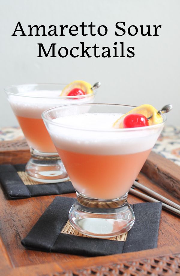 two glasses filled with drinks sitting on top of a wooden tray