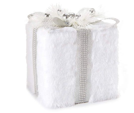 a white gift box with silver ribbon and bows on it's side, wrapped in fluffy material