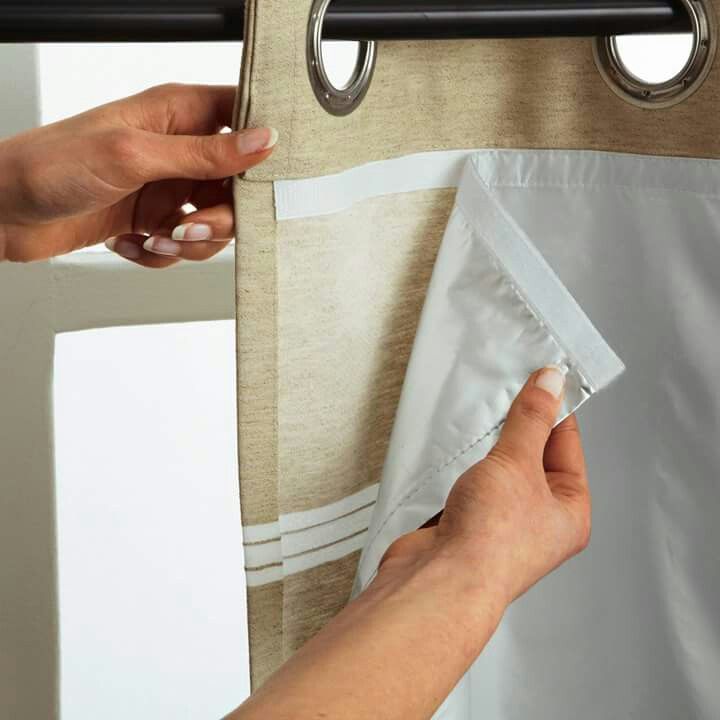 a person is holding onto the curtain with one hand and pulling it out from behind