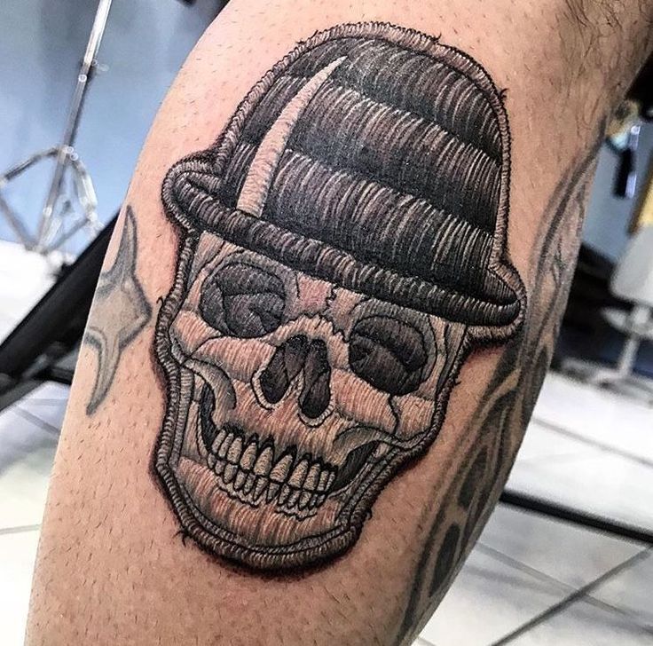 a skull with a hat on it's head is shown in this tattoo design