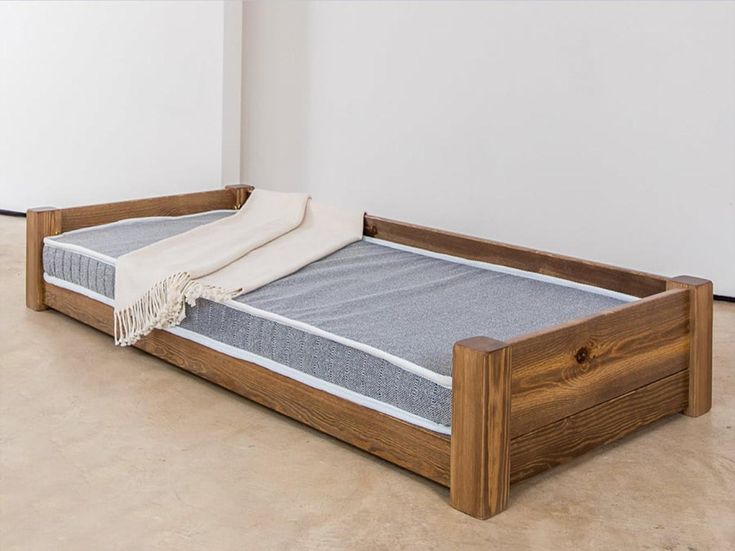 a wooden bed frame with a mattress on it