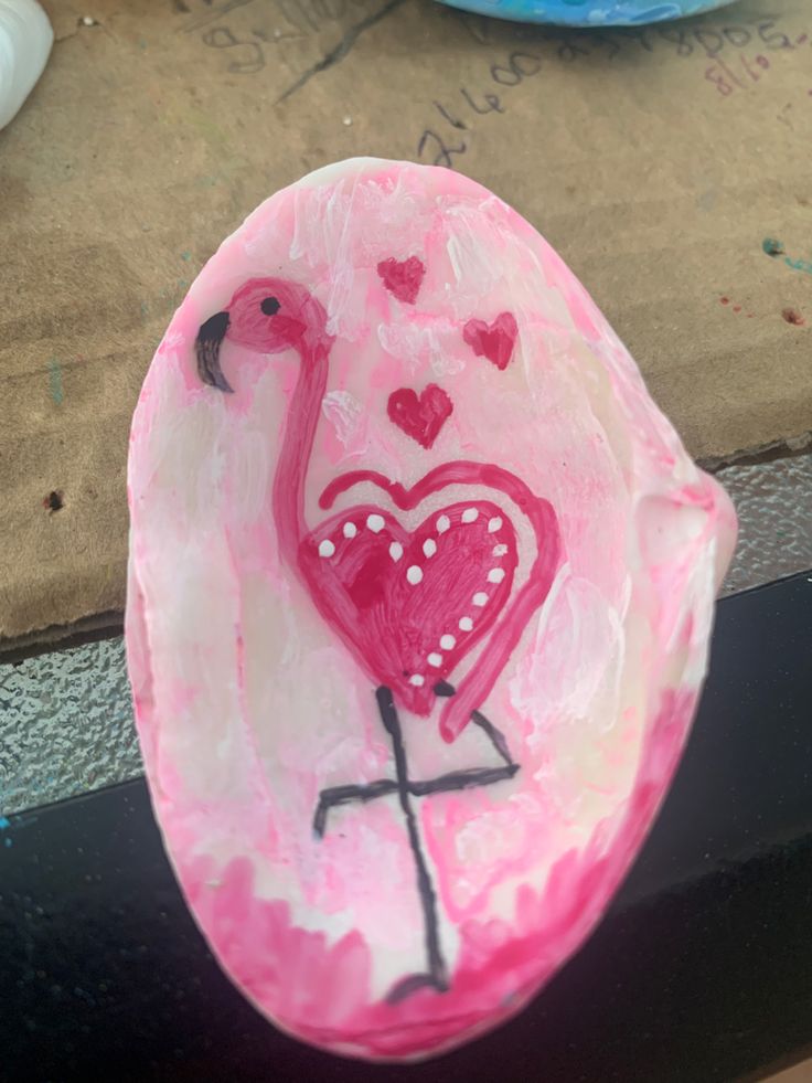 a pink paper plate with a flamingo on it and hearts painted on the side