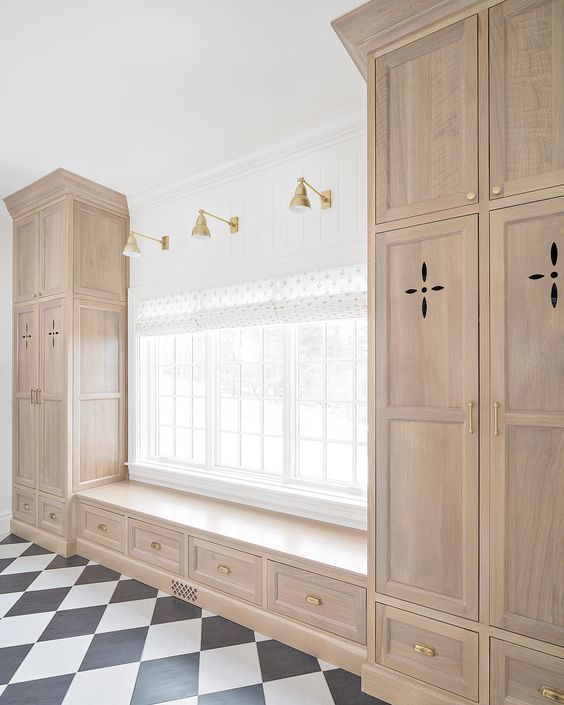 an empty room with wooden cabinets and black and white checkered floor