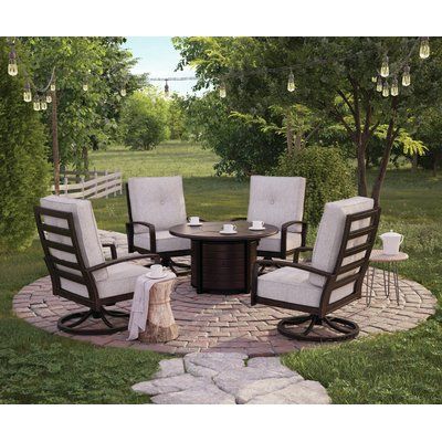 a fire pit surrounded by chairs and tables