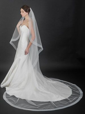 a woman in a white wedding dress and veil