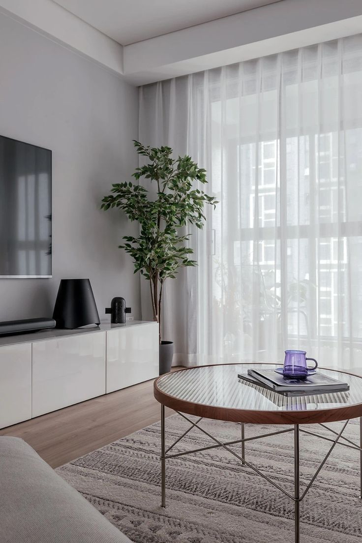 a living room with a couch, coffee table and television on top of the entertainment center